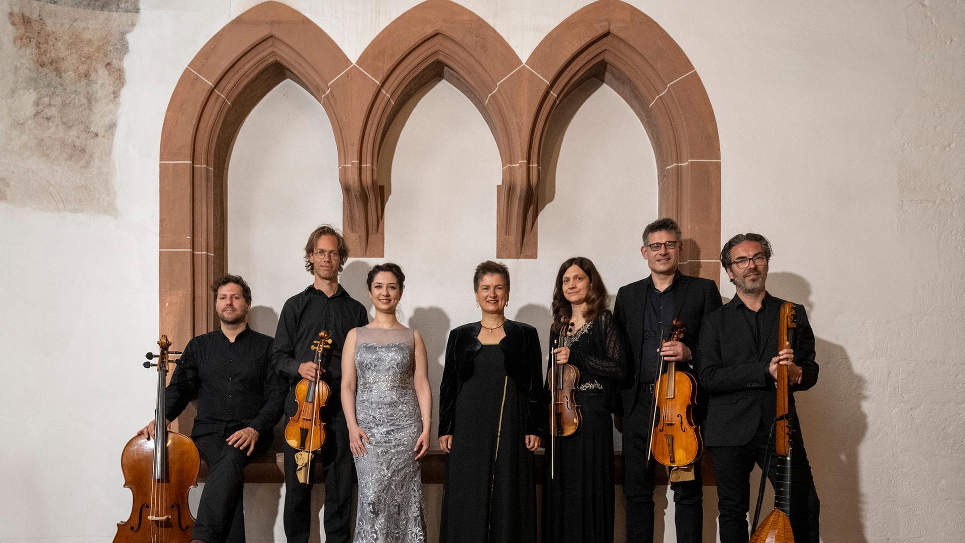 Eine Gruppe von Musikerinnen und Musikern steht vor einer weißen Kirchenwand. Sie tragen in ihre Streichinstrumente in den Händen. Es ist das Ensemble La Floridiana mit seiner Leiterin und Cembalistine Nicoleta Paraschivescu. Eine Gruppe von Musikerinnen und Musikern steht vor einer weißen Kirchenwand. Sie tragen in ihre Streichinstrumente in den Händen. Es ist das Ensemble La Floridiana mit seiner Leiterin und Cembalistine Nicoleta Paraschivescu.