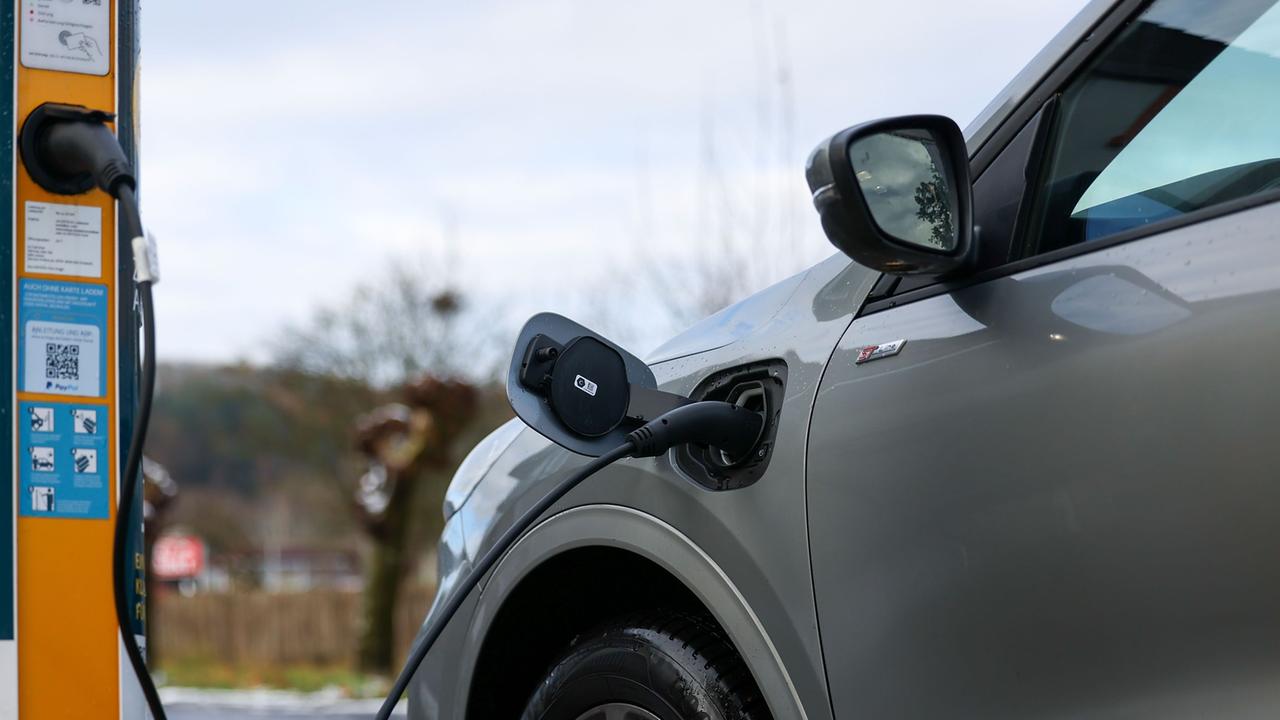 Ein E-Auto wird an einer Ladesäule geladen. 