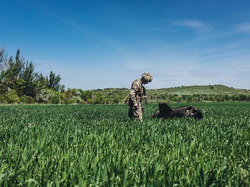Ein ukrainischer Soldat betrachtet eine russische Rakete auf einem Feld in Soledar