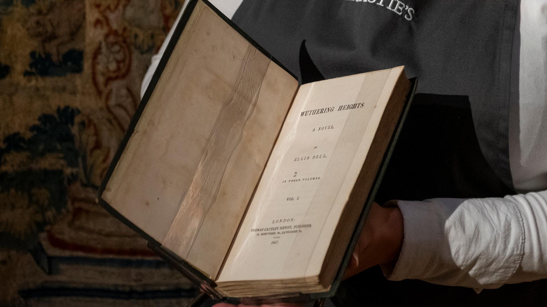 Ein Mitarbeiter von ChristieÄs hält Emily Brontes "Wuthering Heights" aus dem Jahr (1847) in der Hand Ein Mitarbeiter von ChristieÄs hält Emily Brontes "Wuthering Heights" aus dem Jahr (1847) in der Hand
