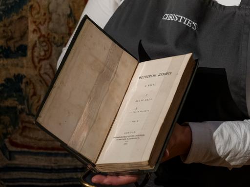 Ein Mitarbeiter von ChristieÄs hält  Emily Brontes "Wuthering Heights" aus dem Jahr (1847) in der Hand