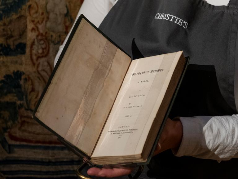 Ein Mitarbeiter von ChristieÄs hält  Emily Brontes "Wuthering Heights" aus dem Jahr (1847) in der Hand
