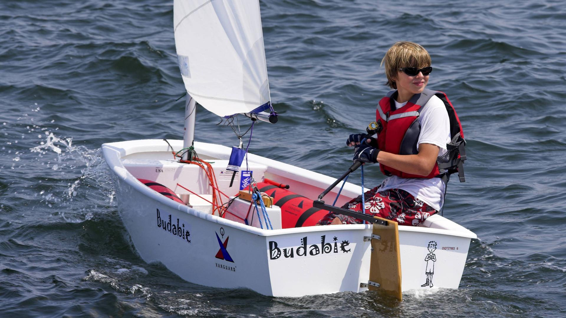 Ein Junge segelt in einem "Optimisten"