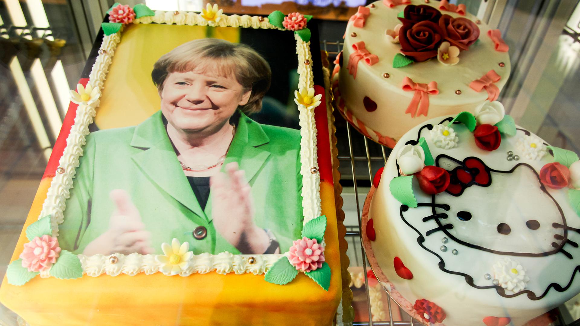 Eine Torte, die mit dem Antlitz der Bundeskanzlerin Angela Merkel dekoriert und mit den deutschen Nationalfarben schwarz, rot, gold umrandet ist, liegt am 29.11.2015 in der Auslage eines Eiscafes auf der Seebrücke in Heringsdorf auf der Insel Usedom. 