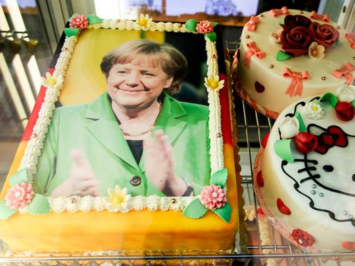Eine Torte, die mit dem Antlitz der Bundeskanzlerin Angela Merkel dekoriert und mit den deutschen Nationalfarben schwarz, rot, gold umrandet ist, liegt am 29.11.2015 in der Auslage eines Eiscafes auf der Seebrücke in Heringsdorf auf der Insel Usedom. 