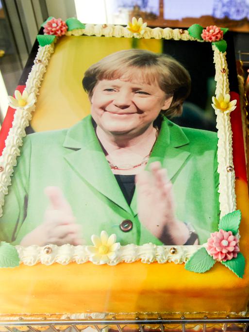 Eine Torte, die mit dem Antlitz der Bundeskanzlerin Angela Merkel dekoriert und mit den deutschen Nationalfarben schwarz, rot, gold umrandet ist, liegt am 29.11.2015 in der Auslage eines Eiscafes auf der Seebrücke in Heringsdorf auf der Insel Usedom. 