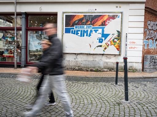Eine Szene in der Fußgängerzone von Schwerin: Ein beschädigtes Wahlplakat der AfD am Tag vor der Landtagswahl 2026 in Mecklenburg-Vorpommern. Darauf steht der Slogan "Werde zum Heimatretter".