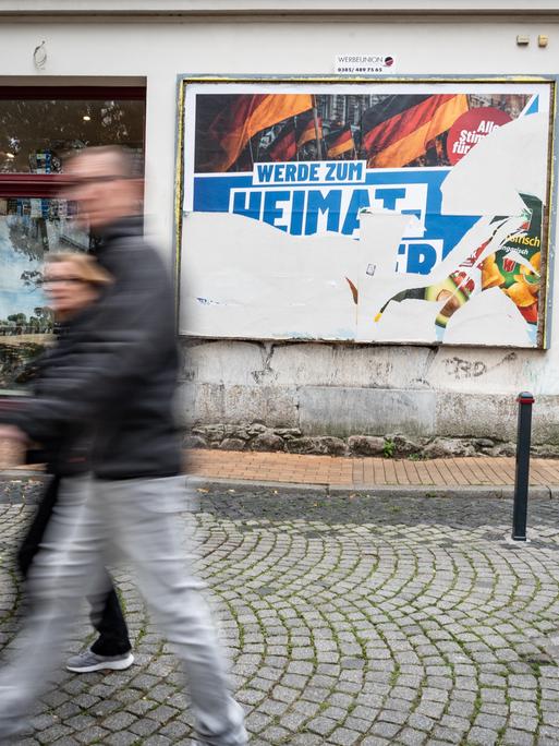 Eine Szene in der Fußgängerzone von Schwerin: Ein beschädigtes Wahlplakat der AfD am Tag vor der Landtagswahl 2026 in Mecklenburg-Vorpommern. Darauf steht der Slogan "Werde zum Heimatretter".