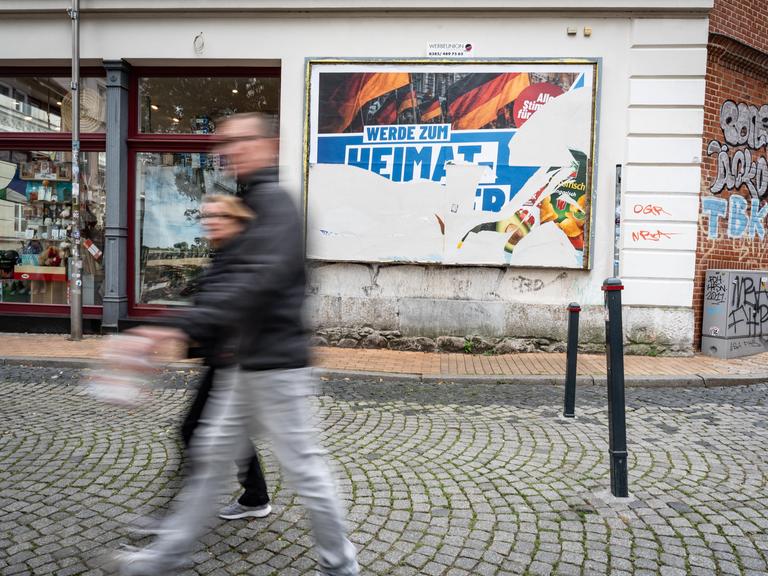Eine Szene in der Fußgängerzone von Schwerin: Ein beschädigtes Wahlplakat der AfD am Tag vor der Landtagswahl 2026 in Mecklenburg-Vorpommern. Darauf steht der Slogan "Werde zum Heimatretter". Eine Szene in der Fußgängerzone von Schwerin: Ein beschädigtes Wahlplakat der AfD am Tag vor der Landtagswahl 2026 in Mecklenburg-Vorpommern. Darauf steht der Slogan "Werde zum Heimatretter".