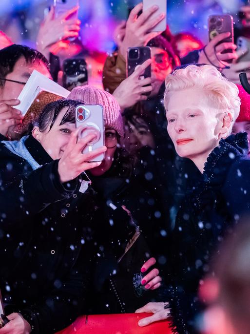 Tilda Swinton, Schauspielerin, lässt sich am Eröffnungsabend der Berlinale auf dem Roten Teppich mit Fans fotografieren. Es wird der Film "Das Licht" gezeigt. Die 75. Internationalen Filmfestspiele Berlin finden vom 13. bis 23. Februar 2025 statt.