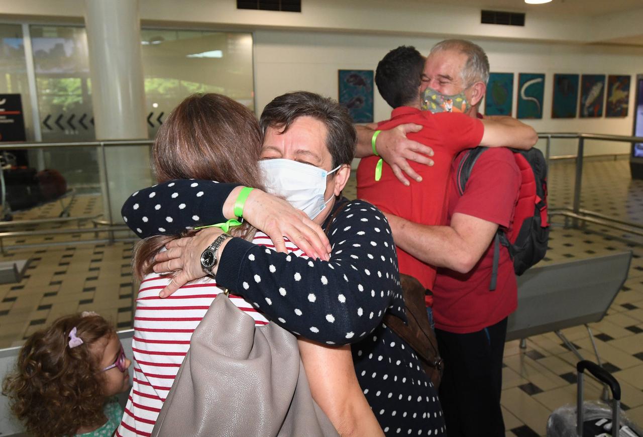 Reisende umarmen sich am Flughafen von Brisbane.