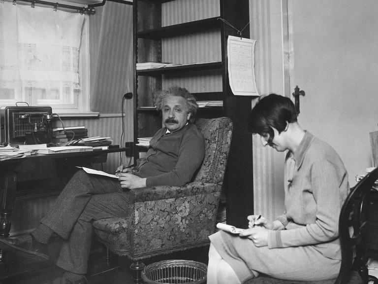 Der Physiker Albert Einstein diktiert seiner Sekretärin eine wissenschaftliche Abhandlung in seiner Mansardenwohnung in Deutschland. Photographie um 1930.