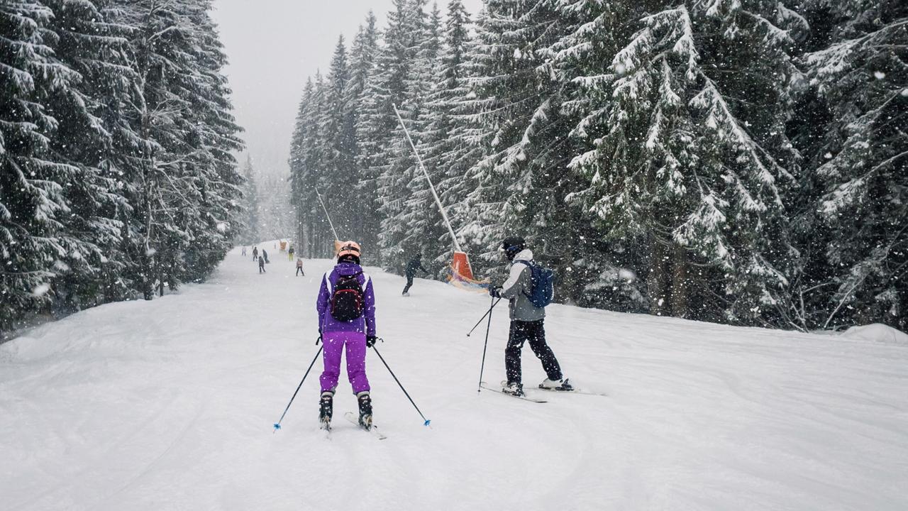 Skifahrer auf einer verschneiten Piste.