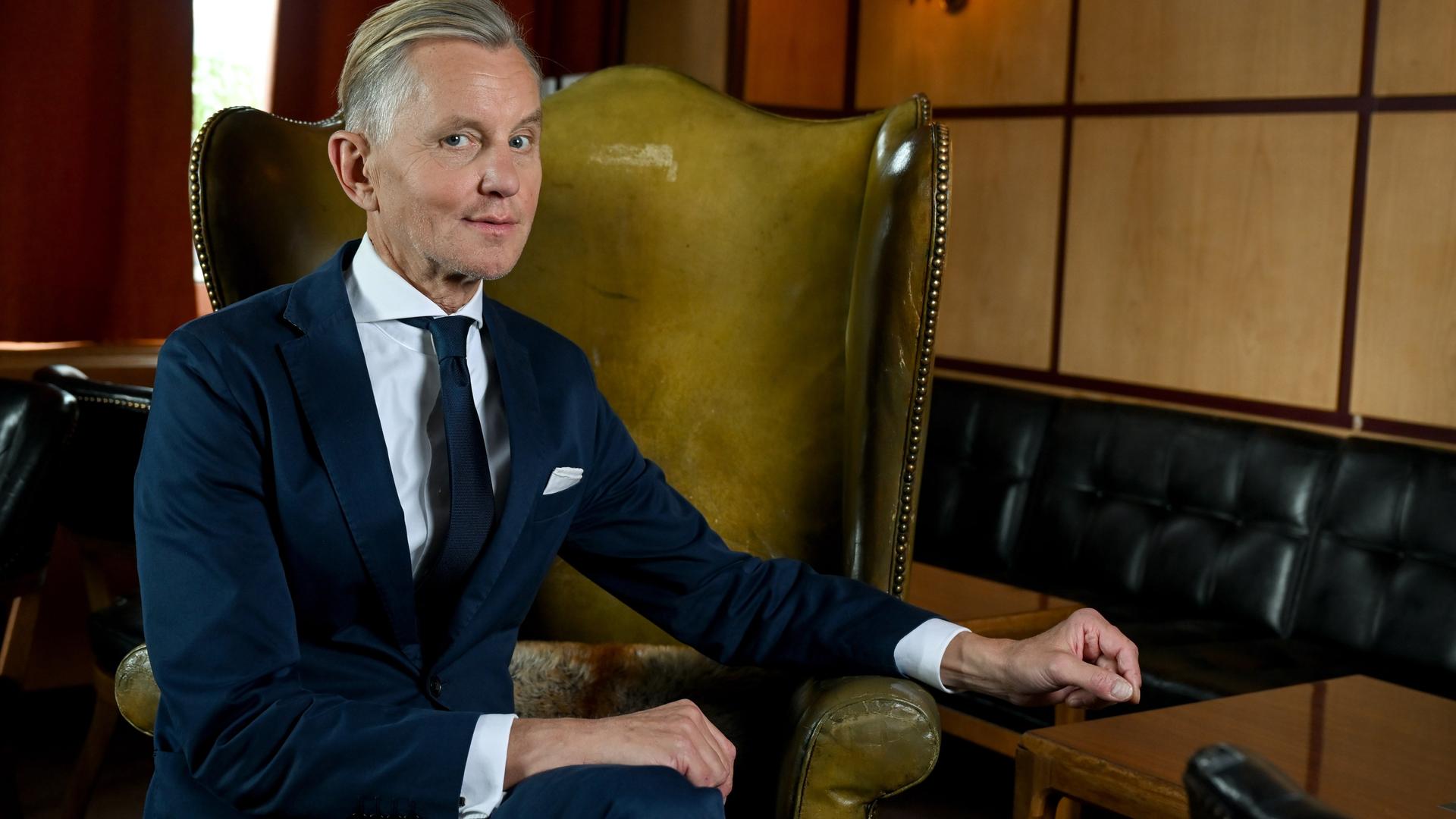 Der Musiker Max Raabe sitzt in einem gelb-grünlichen Lederohrensessel und blickt in die Kamera – vor dem Erscheinen seines Albums "Wer hat hier schlechte Laune", das am 14.10.2022 herauskommt.