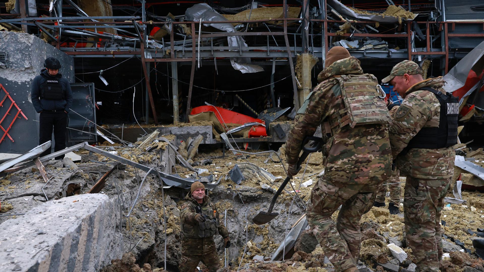 Pioniere und Polizeikräfte untersuchen den Ort eines russischen Raketeneinschlags.