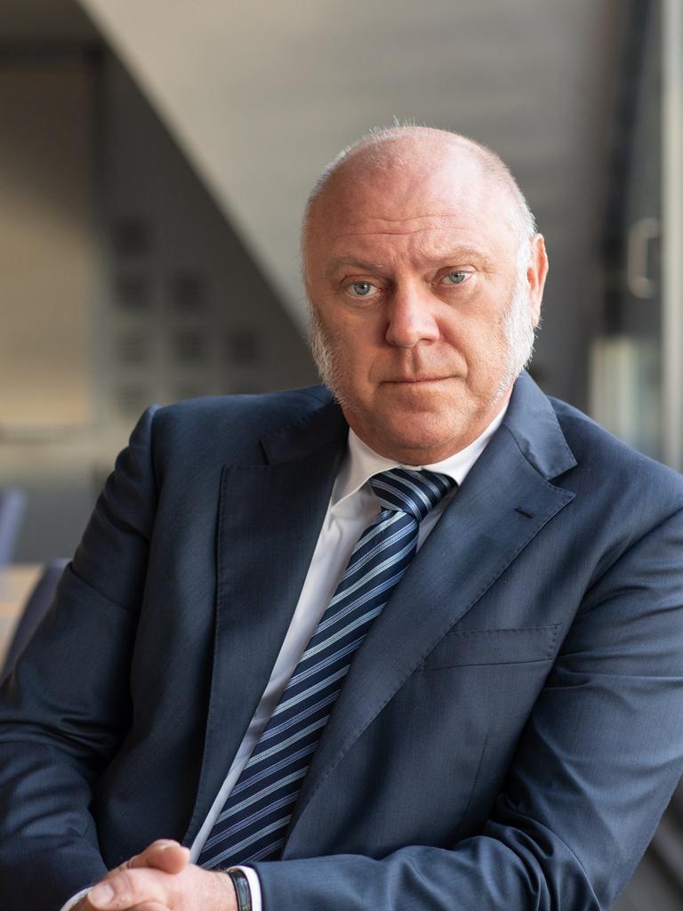 Ulrich Schneider stützt sich auf der Lehne eines Stuhls ab und schaut nachdenklich in die Kamera. Er trägt einen dunkelblauen Anzug und blau gestreifte Krawatte. Ulrich Schneider stützt sich auf der Lehne eines Stuhls ab und schaut nachdenklich in die Kamera. Er trägt einen dunkelblauen Anzug und blau gestreifte Krawatte.