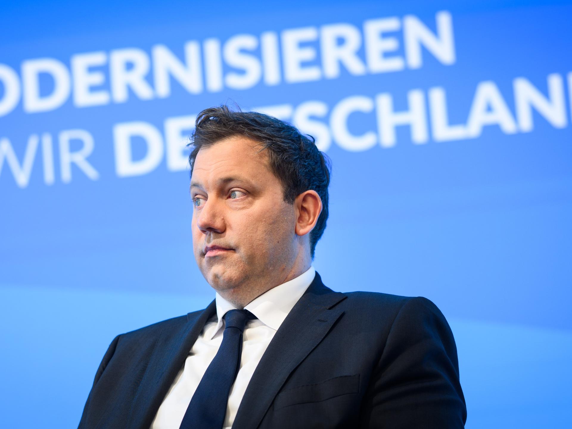 Lars Klingbeil (SPD) sitzt auf einem Podium, im Hintergrund der Schriftzug „Wie modernisieren wir Deutschland?“