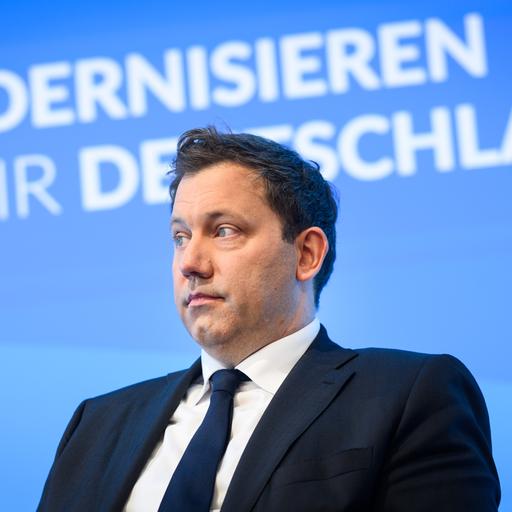 Lars Klingbeil (SPD) sitzt auf einem Podium, im Hintergrund der Schriftzug „Wie modernisieren wir Deutschland?“
