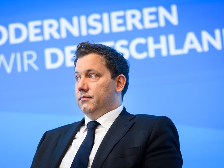 Lars Klingbeil (SPD) sitzt auf einem Podium, im Hintergrund der Schriftzug „Wie modernisieren wir Deutschland?“