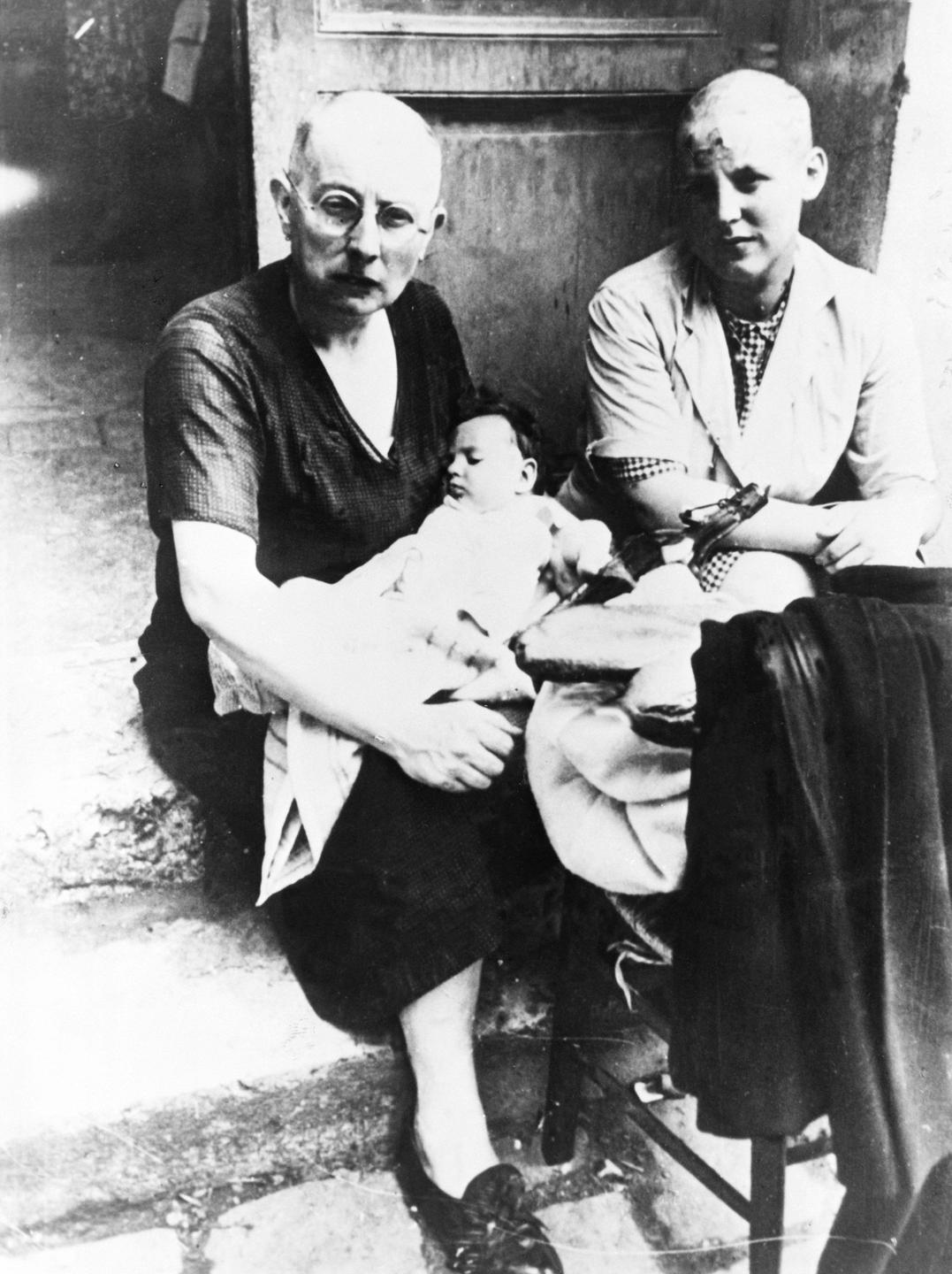 Die Schwarz-weiß-Aufnahme von 1944 zeigt zwei Frauen mit kahlgeschorenem Kopf, von denen eine einen Säugling in den Armen hält.