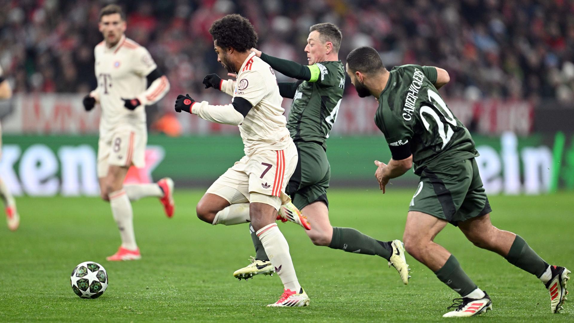 Das Bild zeigt einen Szene aus dem Fußball-Champions-League-Spiel Bayern München gegen Celtic Glasgow. Umringt von Mitspielern kämpfen zwei gegnerische Spieler um den Ball.