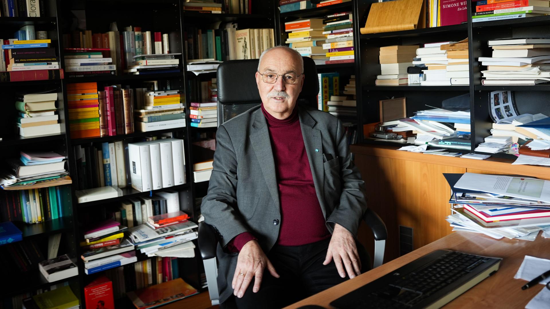 Wolfgang Palaver sitzt an einem Schreibtisch. Hinter ihm sind über Eck volle Bücherregale. Wolfgang Palaver sitzt an einem Schreibtisch. Hinter ihm sind über Eck volle Bücherregale.