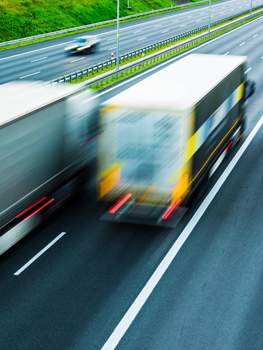 Im Vordergrund fahren auf einer sechsspurigen Autobahn in Polen zwei LKW. Im Hintergrund sind noch zwei Autos erkennbar.