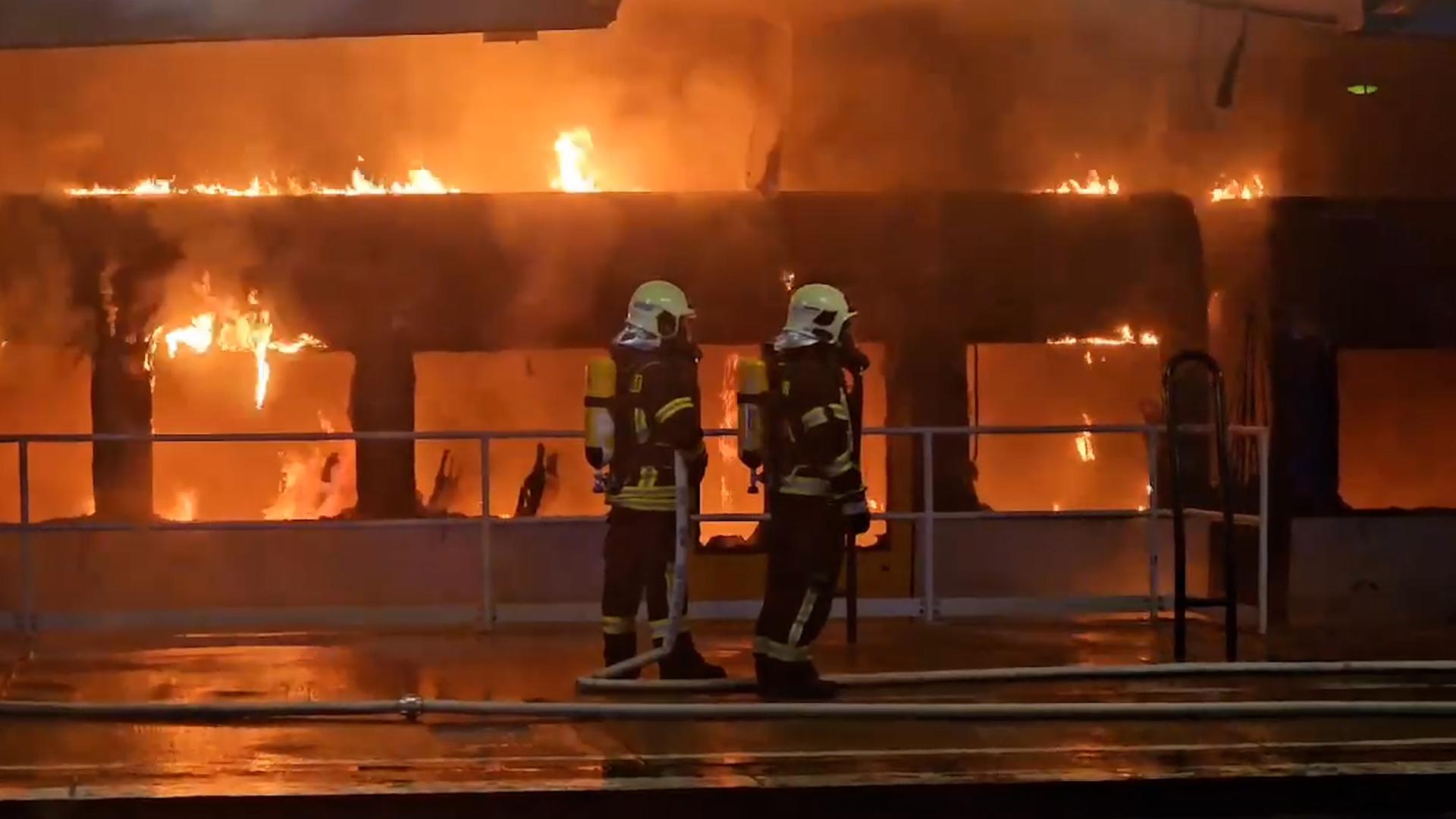 Feuerwehrleute löschen am S-Bahnhof Ahrensfelde einen brennenden Zug.