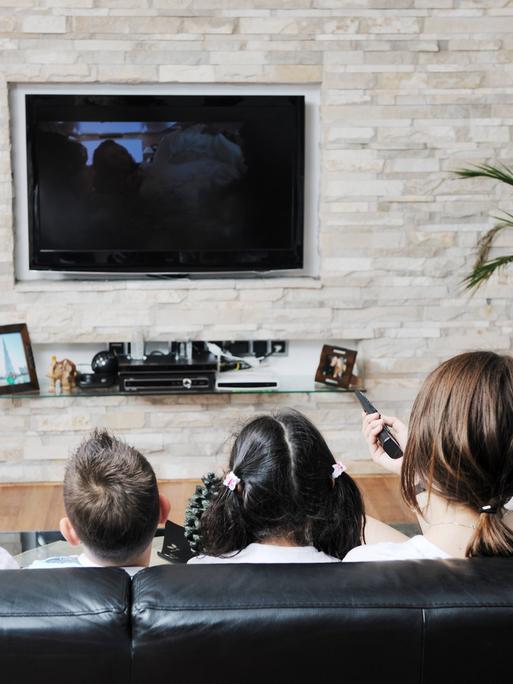 Eine junge Familie sieht fern.