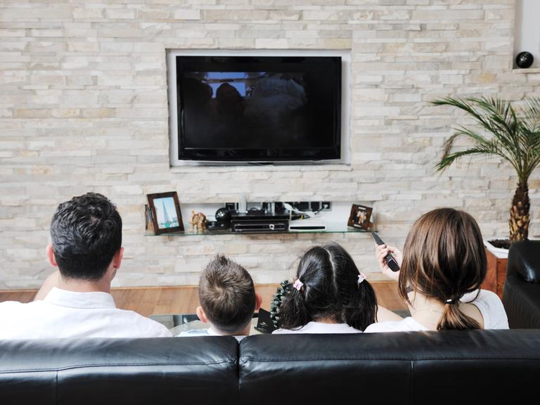 Eine junge Familie sieht fern.