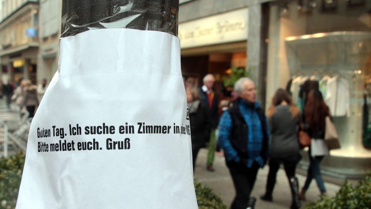 Gesuch mit der Aufschrift "Ich suche ein Zimmer in einer WG" eines Studierenden an einem Laternenpfahl in der Theatinerstraße in München