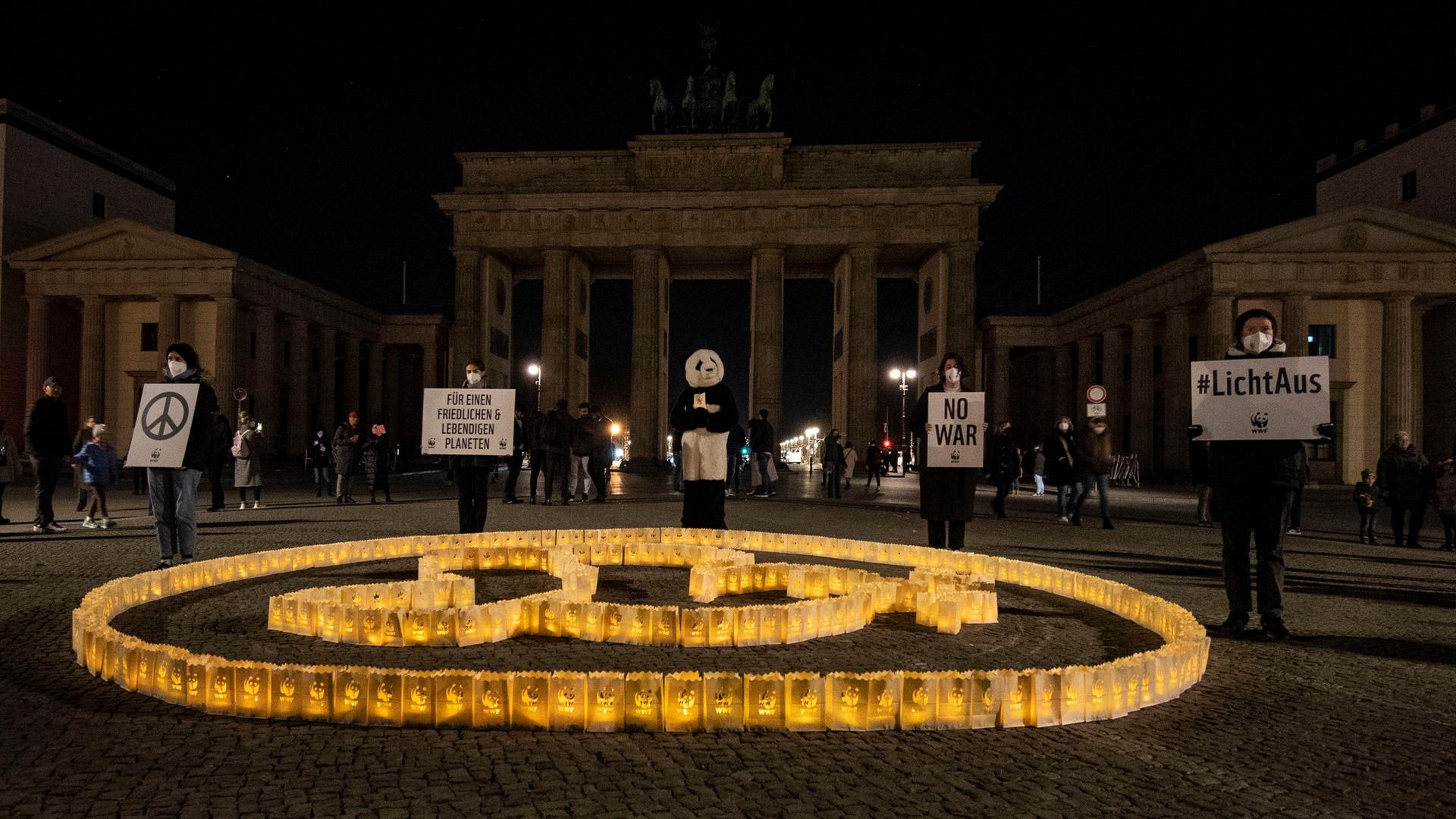 Vor dem Brandenburger Tor in Berlin, dessen Beleuchtung während der weltweit stattfindenden Earth Hour ausgeschaltet ist, stehen kleine Laternen, die in Form einer Friedenstaube aufgestellt wurden.