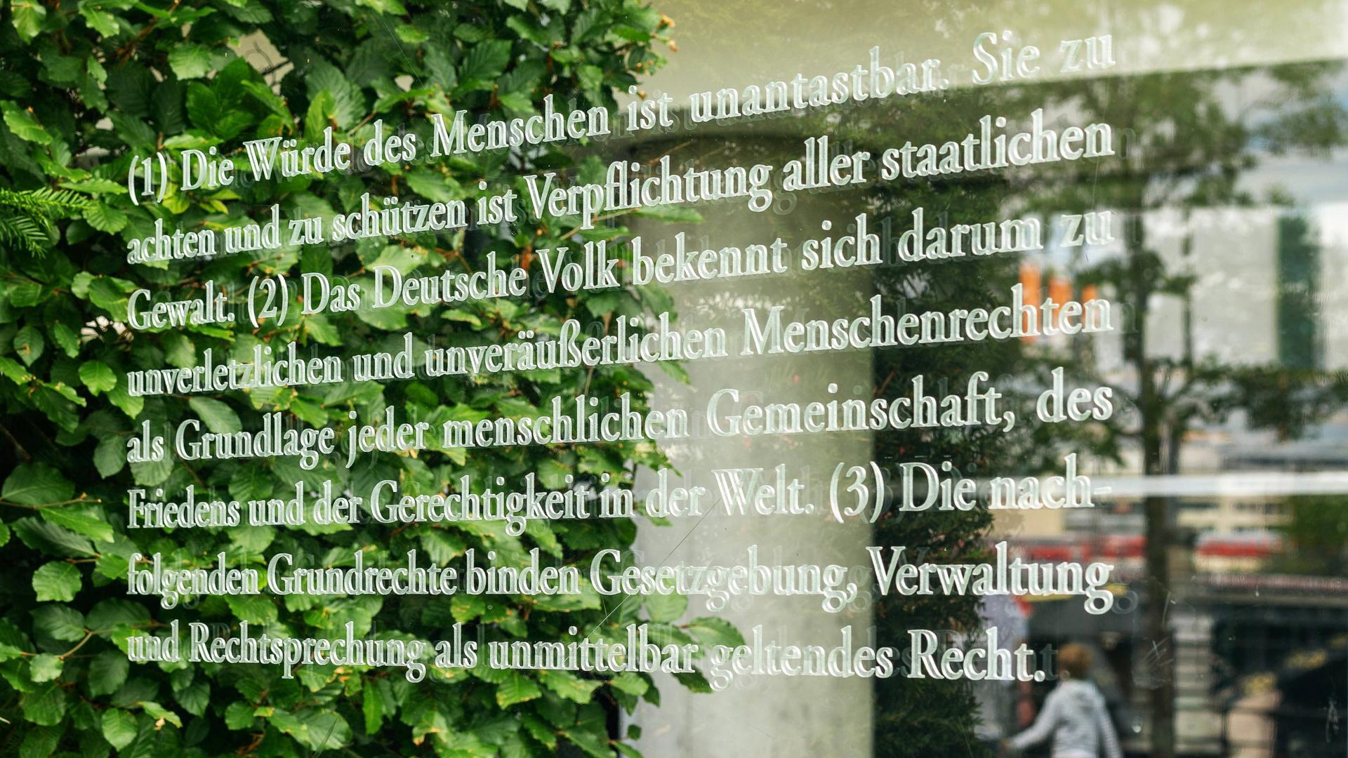 Artikel 1 des Grundgesetzes geschrieben auf einer Glaswand als Teil des Kunstwerks von Dani Karavan Grundgesetz 49 an der Spreepromenade unweite des Reichstages in Berlin Mitte. 