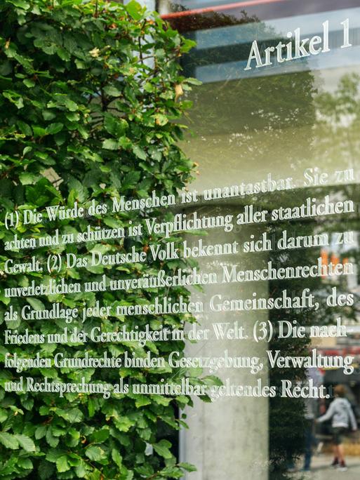 Artikel 1 des Grundgesetzes geschrieben auf einer Glaswand als Teil des Kunstwerks von Dani Karavan Grundgesetz 49 an der Spreepromenade unweite des Reichstages in Berlin Mitte. 