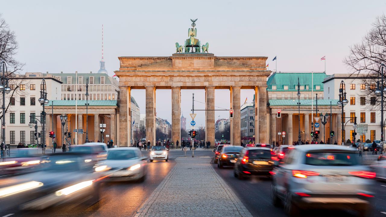 Frontalaufnahme vom Brandenburger Tor. Davor lange Autoschlangen.