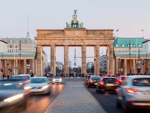 Frontalaufnahme vom Brandenburger Tor. Davor lange Autoschlangen.