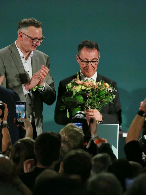 Cem Özdemir erhält auf der Grünen-Wahlparty nach den ersten Prognosen Blumen.