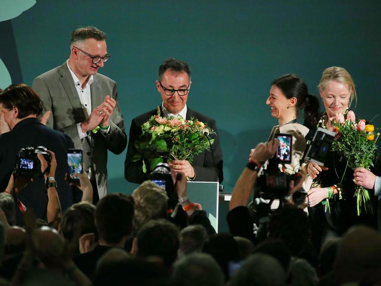 Cem Özdemir erhält auf der Grünen-Wahlparty nach den ersten Prognosen Blumen.
