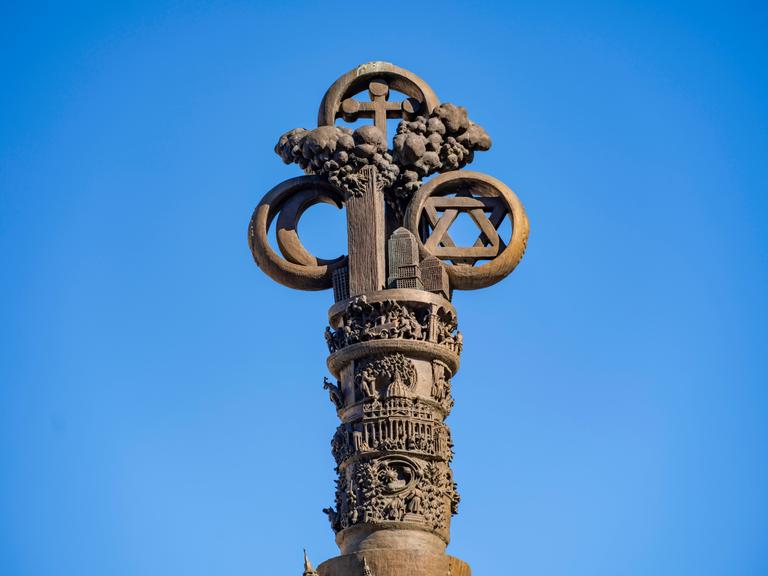 Ein Bronzedenkmal  des Künstlers Jürgen Weber, das in Braunschweig steht, zeigt einen wolkigen Himmel, der von den drei Symbolen der großen Religionen umgeben ist: Ein Mond, ein Stern und ein Kreuz.