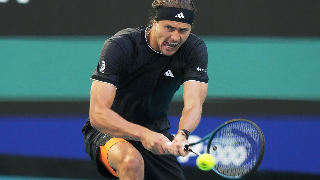 Alexander Zverev schlägt mit angestrengtem Gesichtsausdruck einen Tennisball zurück. 