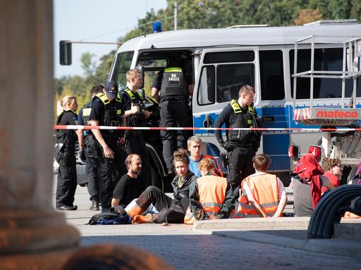 Polizeibeamte stehen am Brandenburger Tor um eine Gruppe festgesetzter Mitglieder der Klimaschutzgruppe Letzte Generation. 