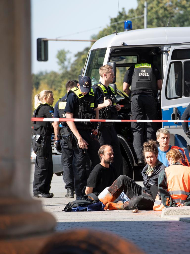 Polizeibeamte stehen am Brandenburger Tor um eine Gruppe festgesetzter Mitglieder der Klimaschutzgruppe Letzte Generation. 