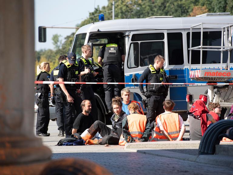 Polizeibeamte stehen am Brandenburger Tor um eine Gruppe festgesetzter Mitglieder der Klimaschutzgruppe Letzte Generation. 