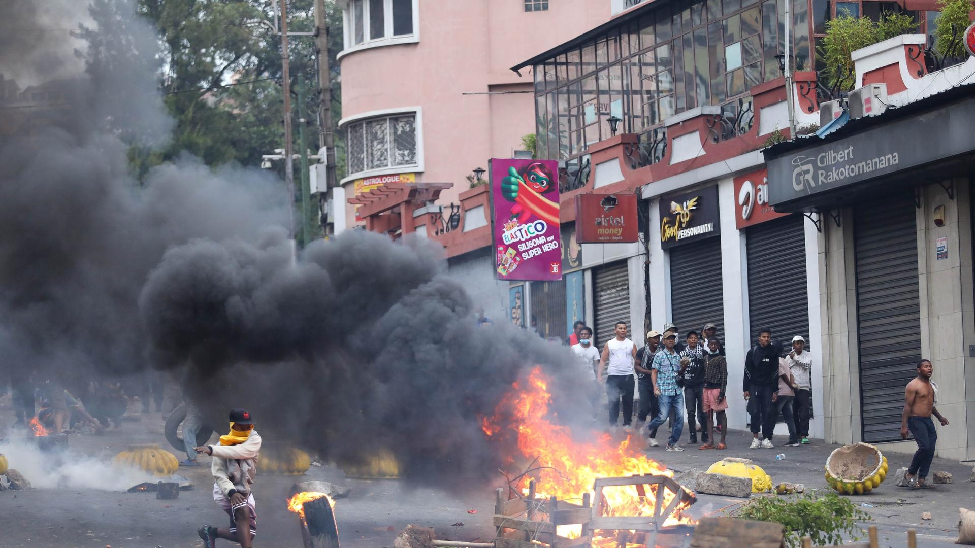 Demonstranten stehen in Antananarivo der Bereitschaftspolizei gegenüber. Einige sind vermummt, angezündete Sachen blockieren eine Straße.
Demonstranten stehen in Antananarivo der Bereitschaftspolizei gegenüber. Einige sind vermummt, angezündete Sachen blockieren eine Straße.