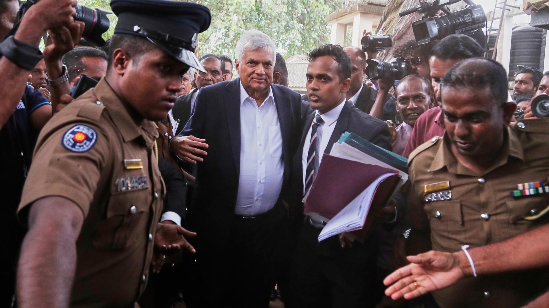 Colombo: Der ehemalige sri-lankische Präsident Ranil Wickremesinghe (M) wird von der Polizei zu einem Gericht gebracht. Colombo: Der ehemalige sri-lankische Präsident Ranil Wickremesinghe (M) wird von der Polizei zu einem Gericht gebracht.