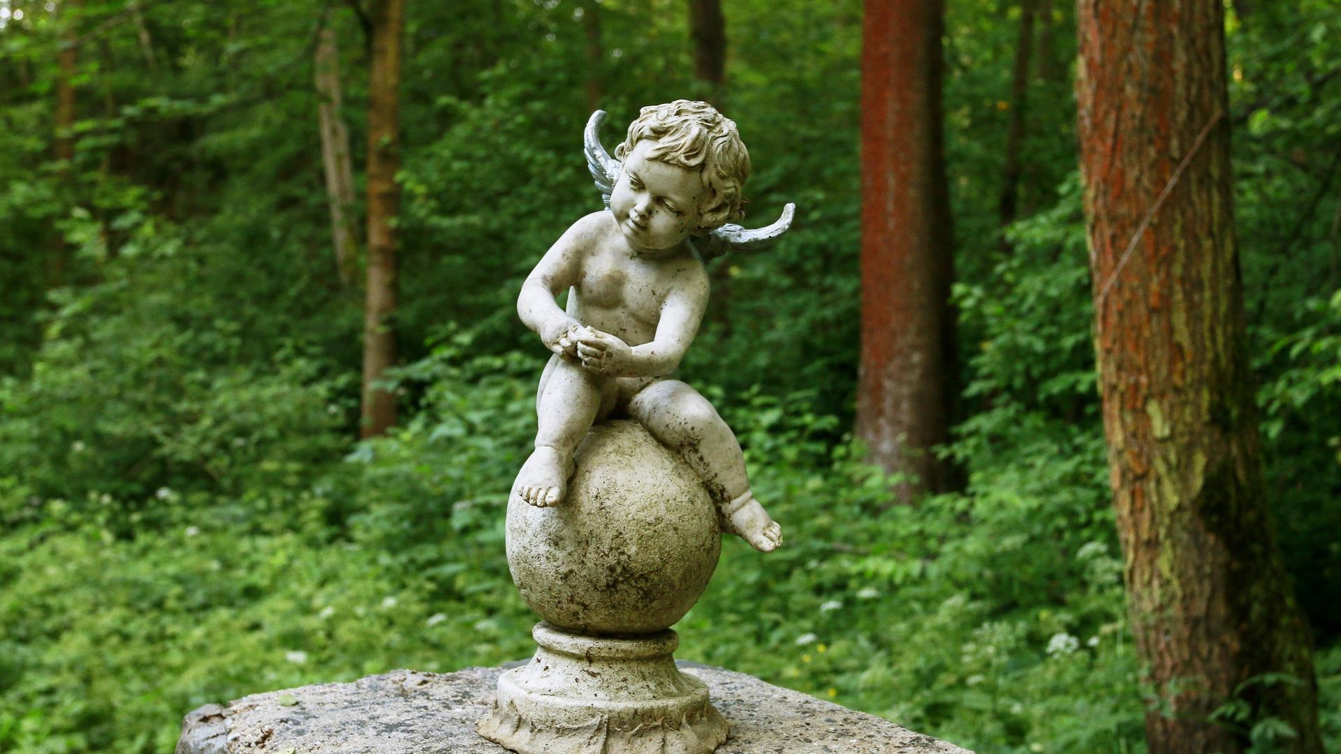 Ein kleiner sitzender Engel auf einem Friedhof. Ein kleiner sitzender Engel auf einem Friedhof.