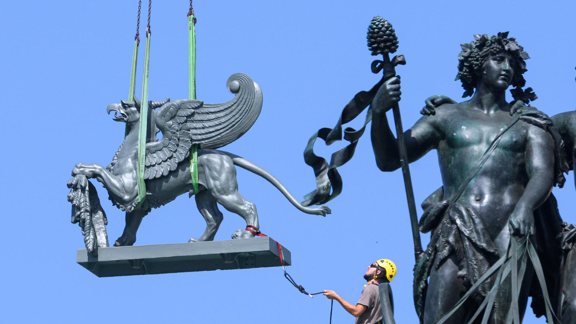 An Seilen gesichert wird die Plastik eines Greifen per Kran wieder auf das Dach Semperoper gehoben An Seilen gesichert wird die Plastik eines Greifen per Kran wieder auf das Dach Semperoper gehoben