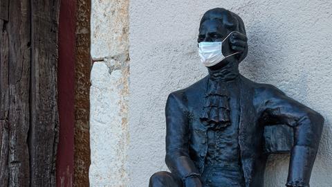Eine Skulptur als Denkmal an Giacomo Casanova. Die Skulptur trägt eine medizinische Maske.