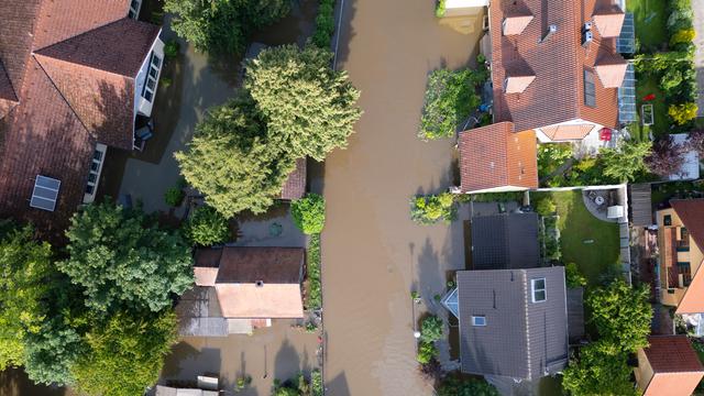 Eine Luftaufnahme zeigt überflutete Häuser im bayerischen Ort Reichersthofen.