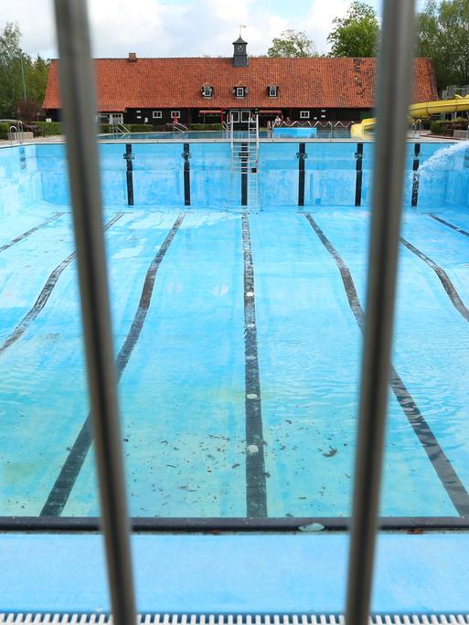 Ein leeres Schwimmbecken, das gerade mit dem ersten Wasser befüllt wird.